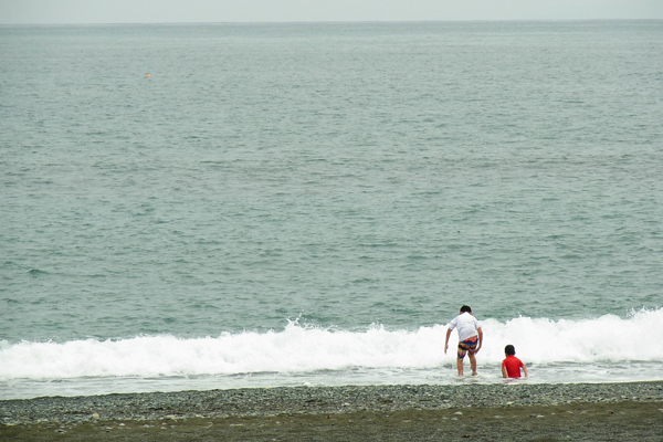 御幸の浜海岸で波遊びをする子供